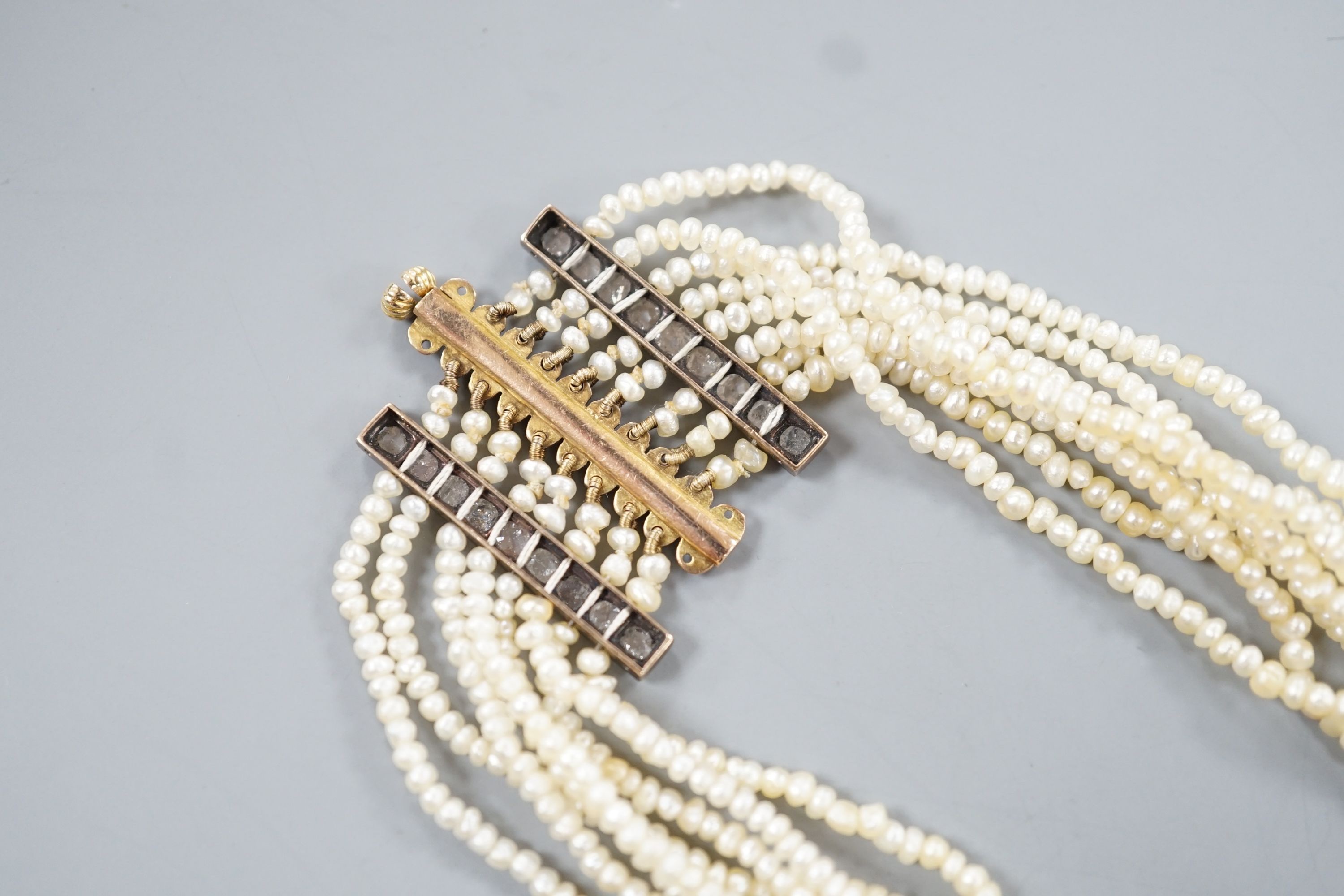 A 19th century multi-strand seed pearl choker necklace with yellow metal and rose cut diamond set clasp and trellis motif, approx. 40cm, gross weight 31.1 grams.